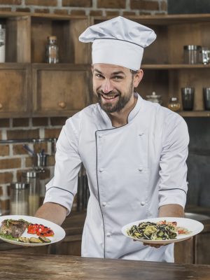 male-cook-standing-kitchen-presenting-delicious-dish